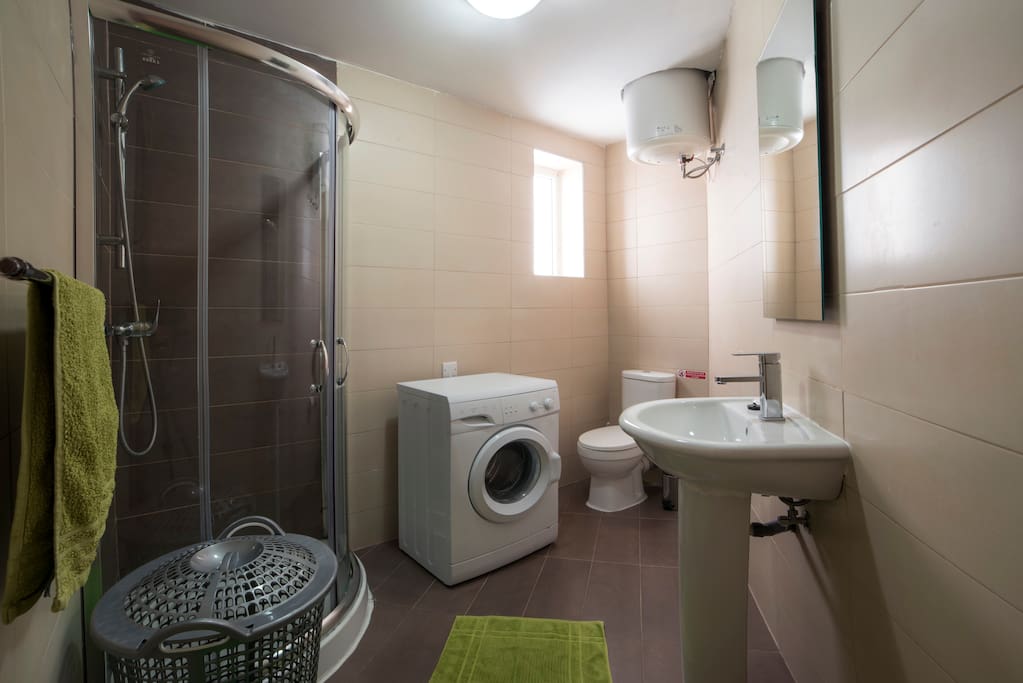 bathroom with shower and washing machine