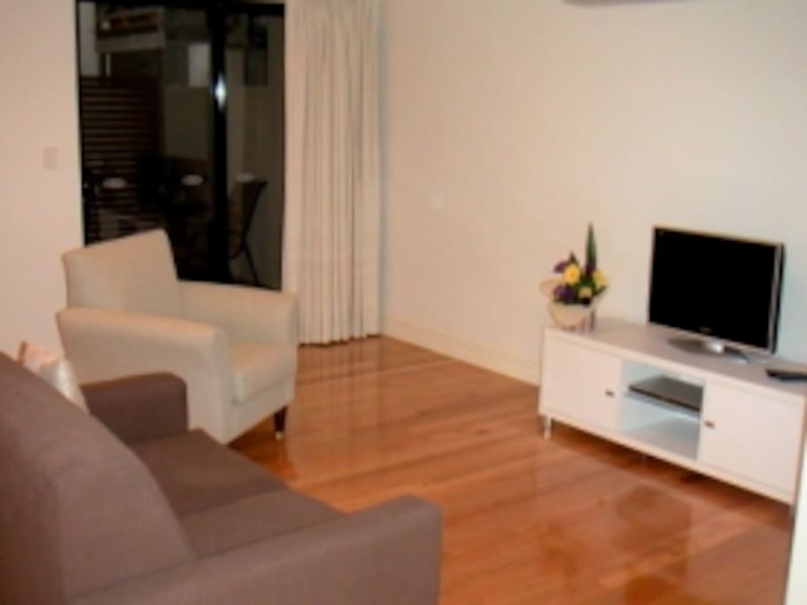 Sitting area has access to outdoor space (between buildings) seen at the rear. Cable TV is available as is free WIFI and local phone calls.