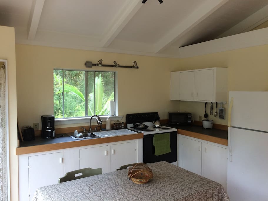 Closer view on kitchen, pots and pans, toaster, coffee maker, and microwave. Great garden view!