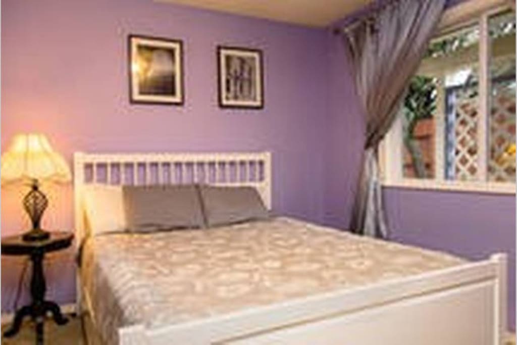 Comfortable bed with black out curtains and desk area
