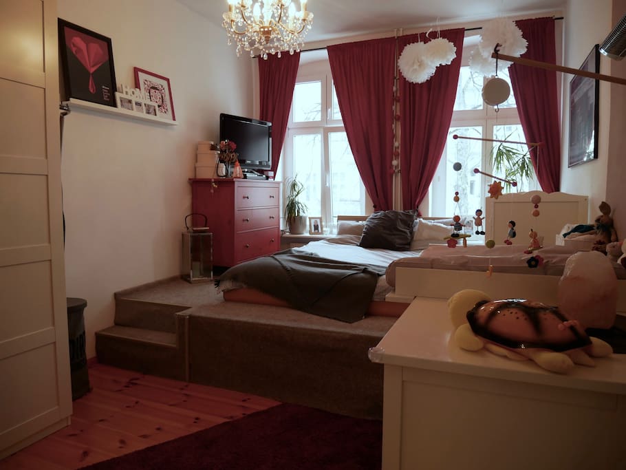 Bedroom with large double bed and a baby bed