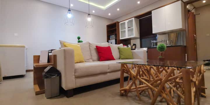 Sofa at the living room to watch curve Samsung Smart TV. You can watch TV programs, Netflix, and karaoke here. 