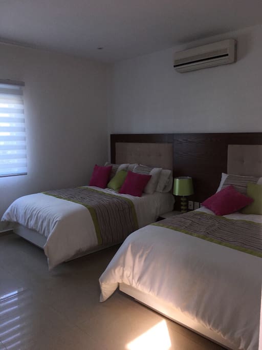 Recámara de las niñas con dos cañas matrimoniales, a/a. Incluye Closets y una Televisión con cable.