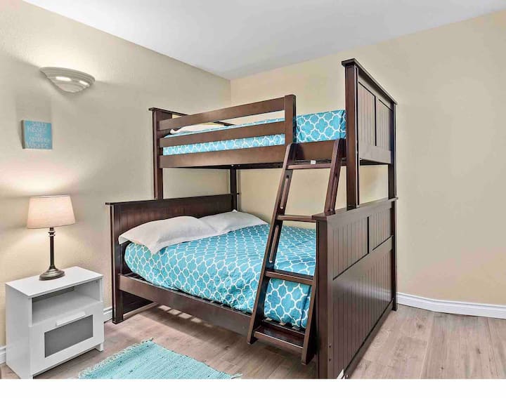 ห้องนอนชั้นล่างมีเตียงคู่อยู่ชั้นล่างและเตียงสองชั้นบน 