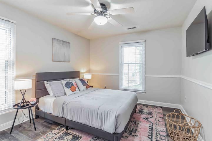 חדר שינה שני עם מיטת קווין סייז. טלוויזיה חכמה של Roku על הקיר.