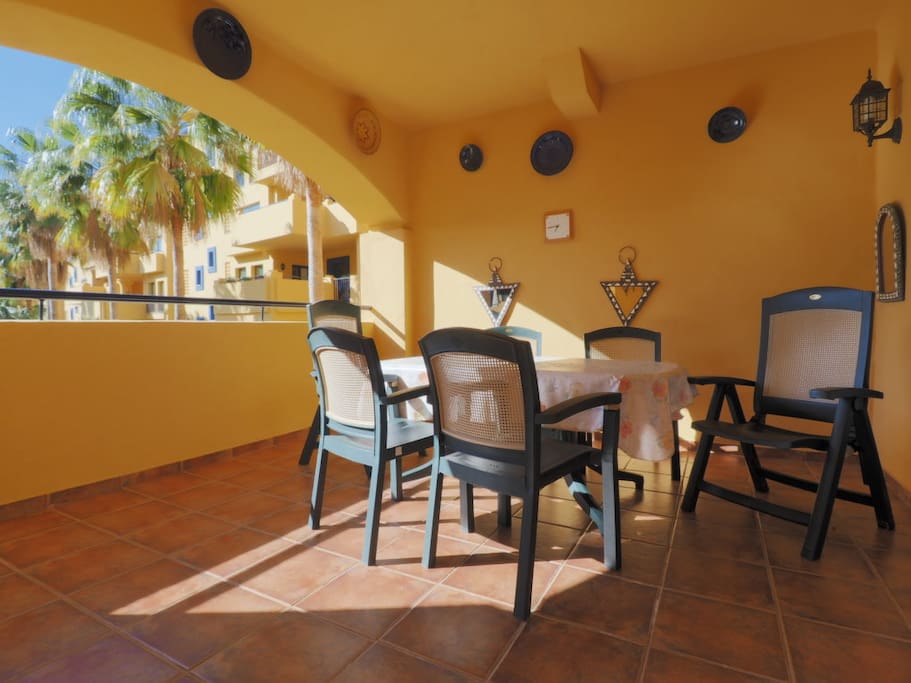 Große, sonnige Terrasse mit Gartenmöbeln