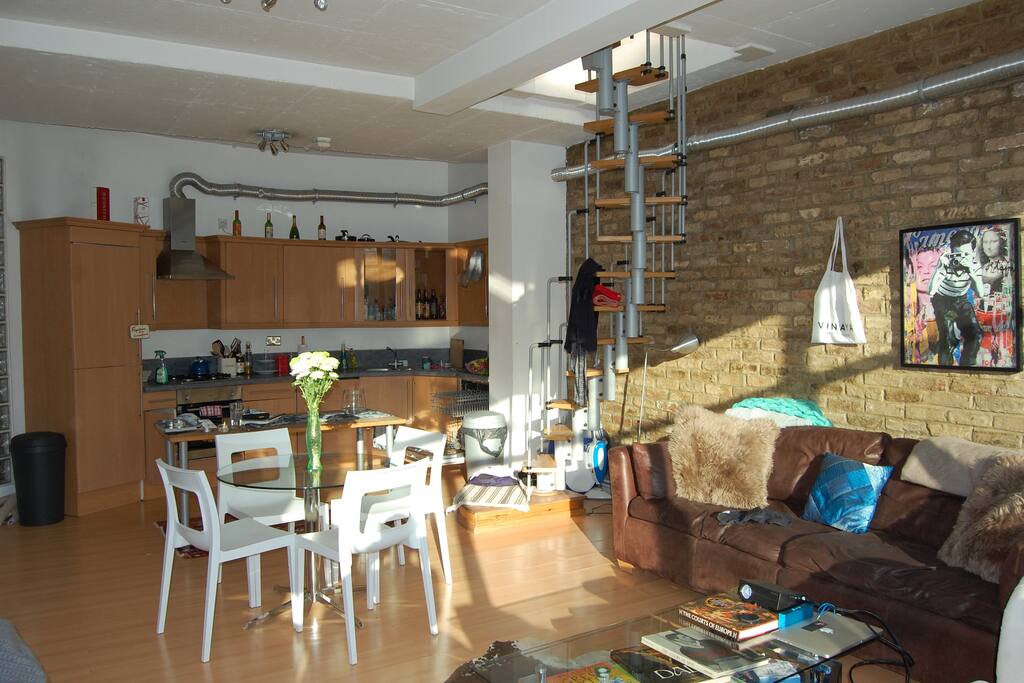 Open plan living room and kitchen with stairs leading up to the private roof