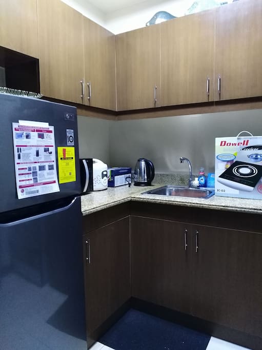 Kitchen is equipped with dining set, cooking wares, ref, kettle microwave, rice cooker and induction cooker