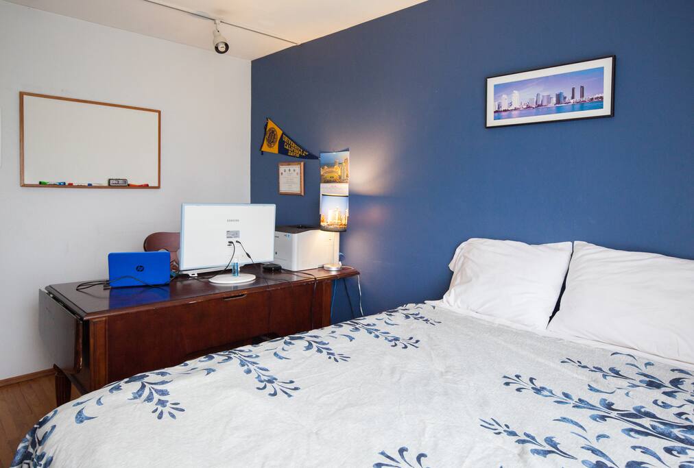 Office bedroom has desk, monitor and color printer