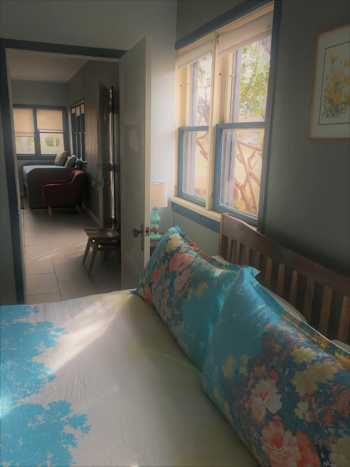 Vue de la chambre par une porte ouverte sur le salon.