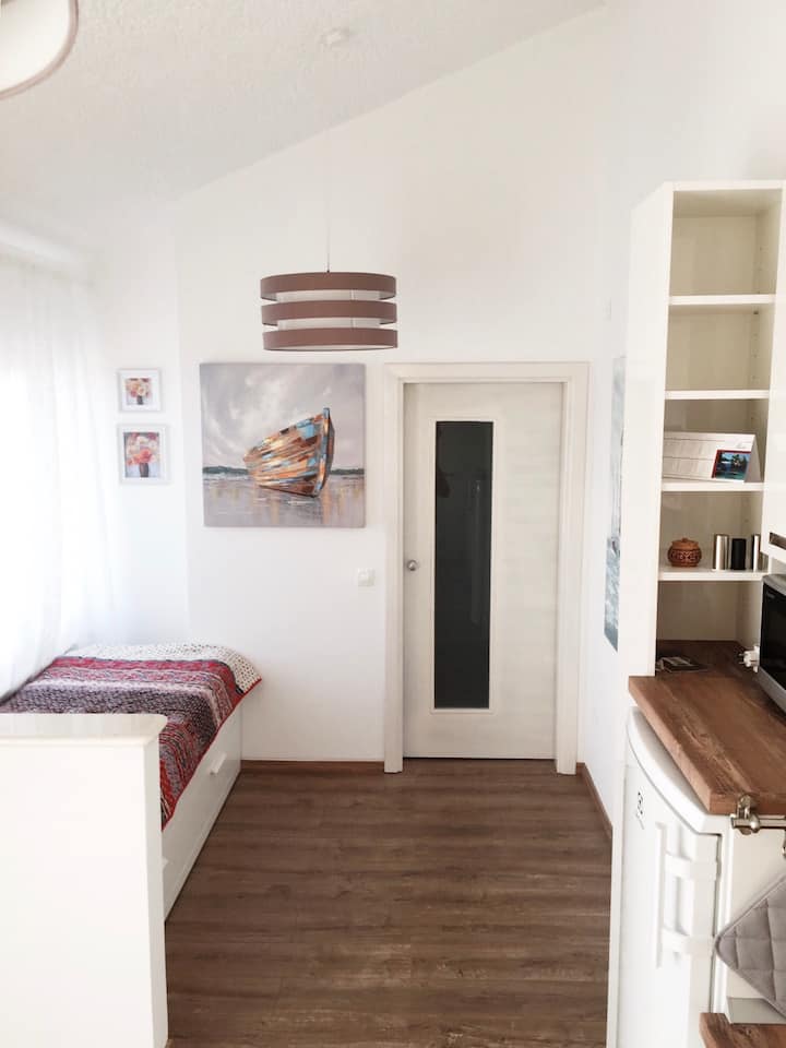 客厅配有双人沙发床；通往卫生间和卧室的滑动门