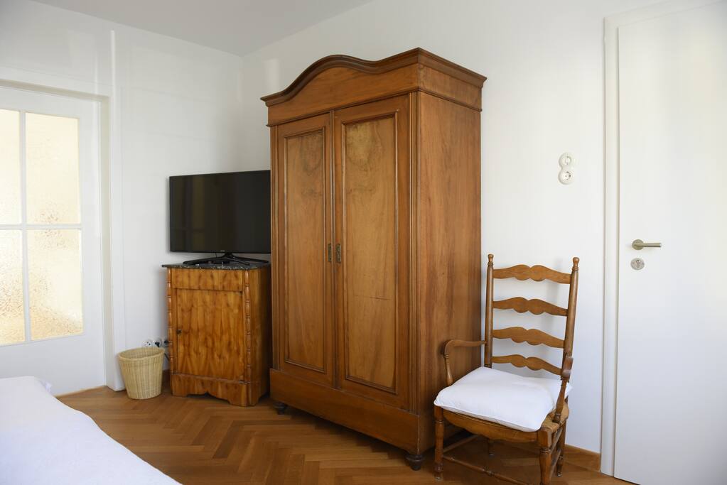 Alt - und Neu: Möbel aus den 1920ern und moderne Technik: LED-TV und Apple-TV.