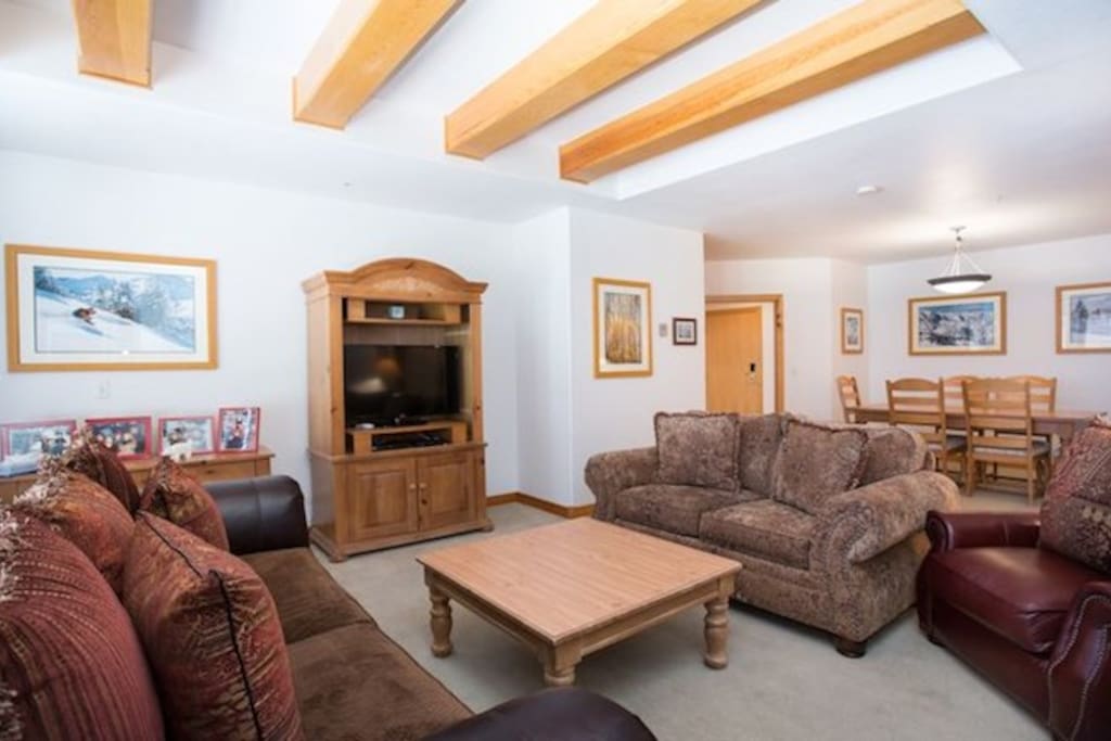 Sink into the plush sofas in this warm and bright living space and enjoy the TV and wood-burning fireplace.