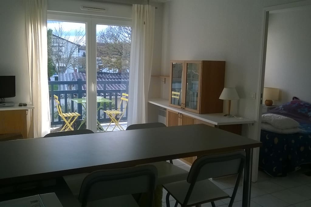 Coin repas, vue sur la chambre à droite et devant sur le coin salon et la terrasse