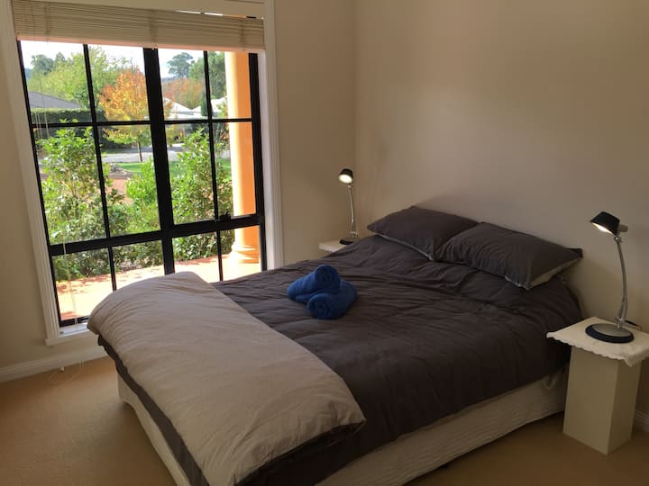 P.L. Travers Room. Двоен кревет со тивок, лиснат поглед кон градината.