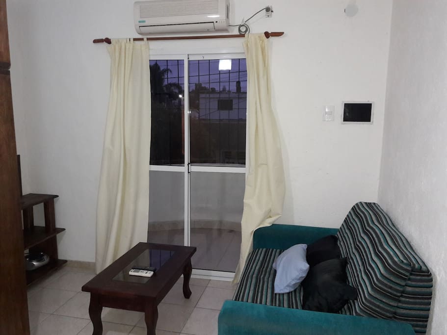 Mini living con tv y mesa ratonera, vista para el balcón.