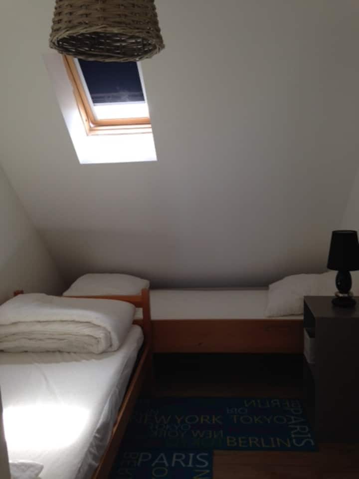 غرفة صغيرة تضم سريرين فرديين