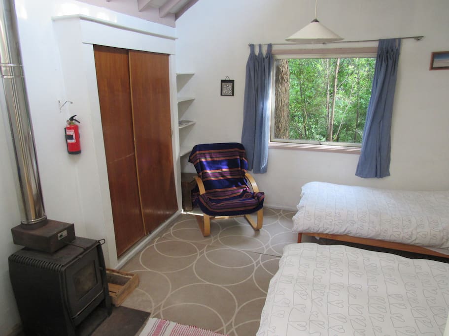 Dormitorio con vista al humedal. Closet para guardar artículos personales y calefacción a leña