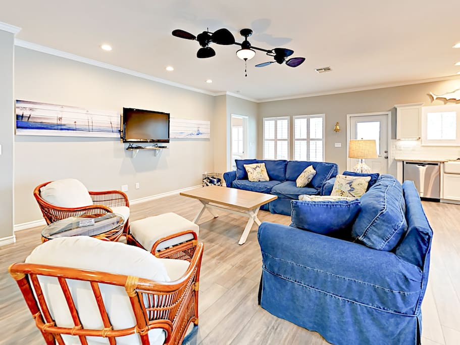 An open concept living area features plush coastal-inspired furnishings.
