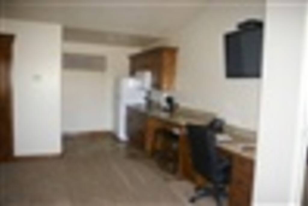 Kitchenette including full size fridge, microwave and all cookware and place settings. Also dining stools and desk area.