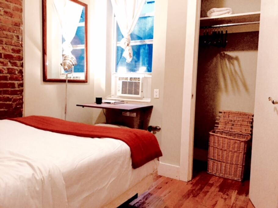 Closet with hangers and a laundry basket.