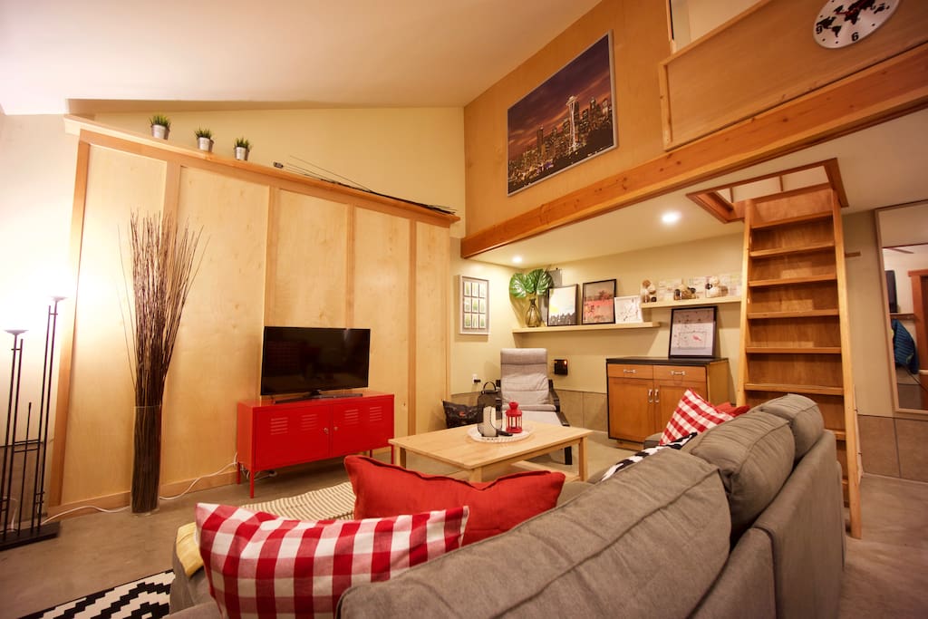 The main living area has a large sectional couch, TV and an Apple TV with DirecTV service, along with a reading chair.