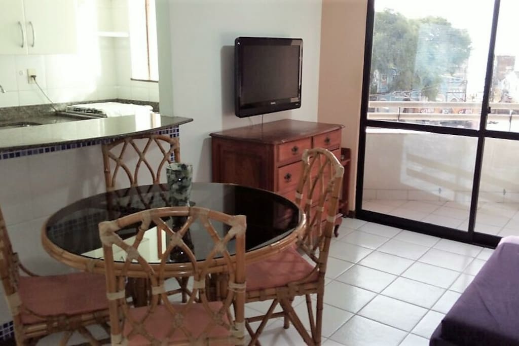 Aconchegante sala com cozinha americana e varanda