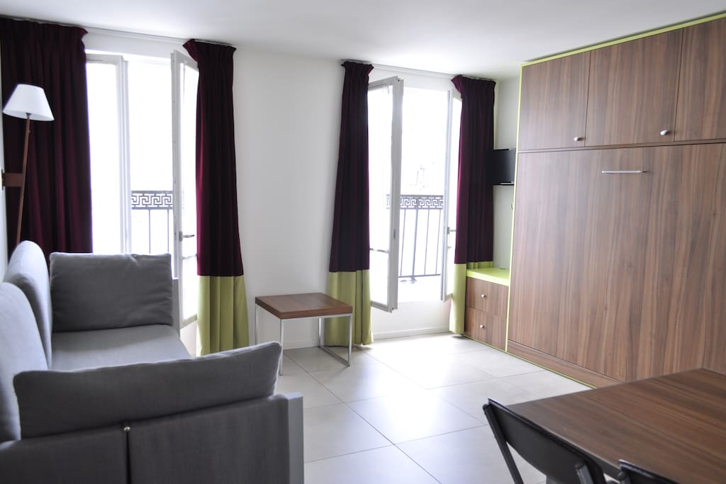 Living room equipped with flippable double bed, sofa bed and dining table