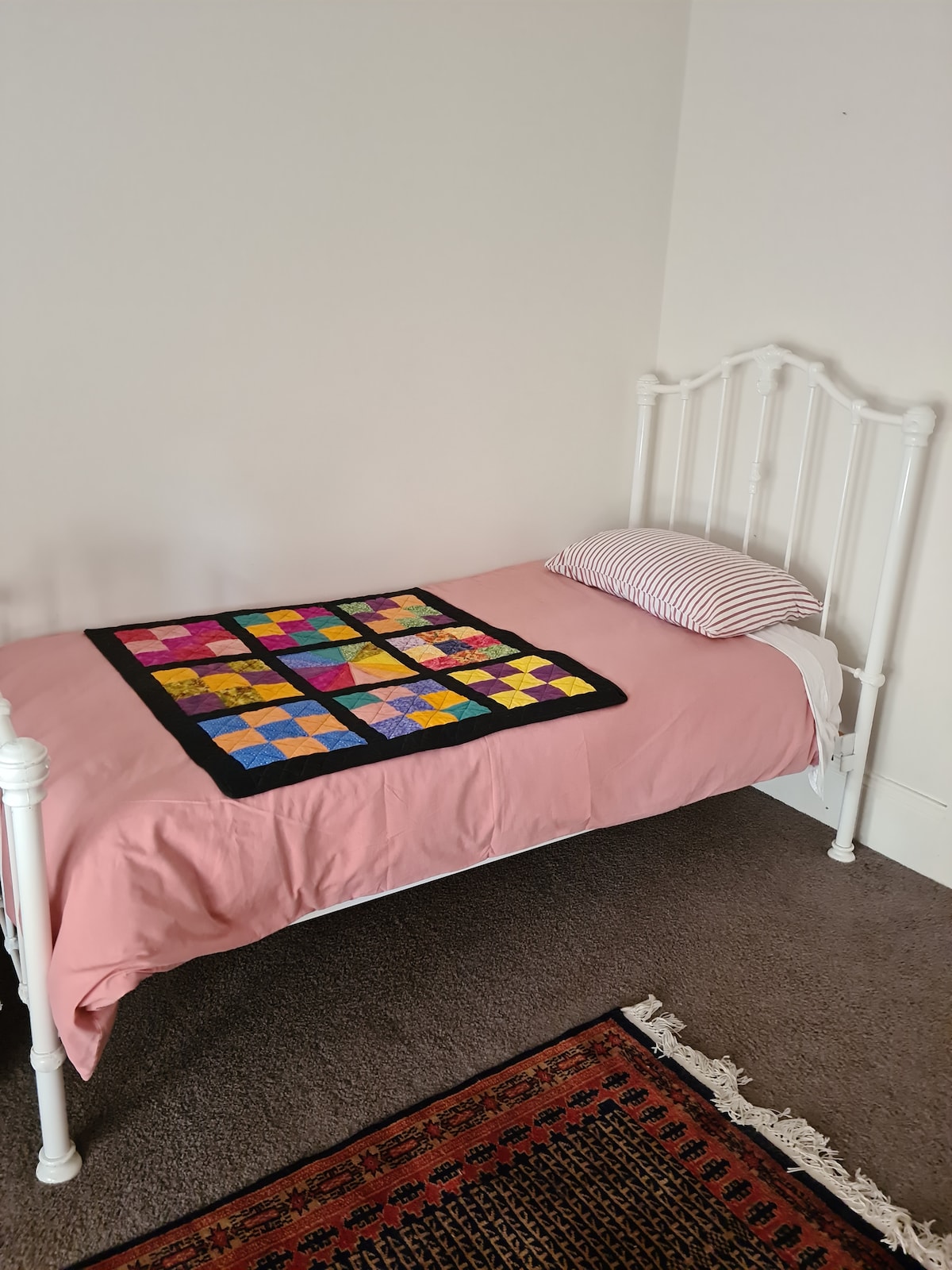 Dormitorio individual con portacot, bañera para bebés y juguetes.