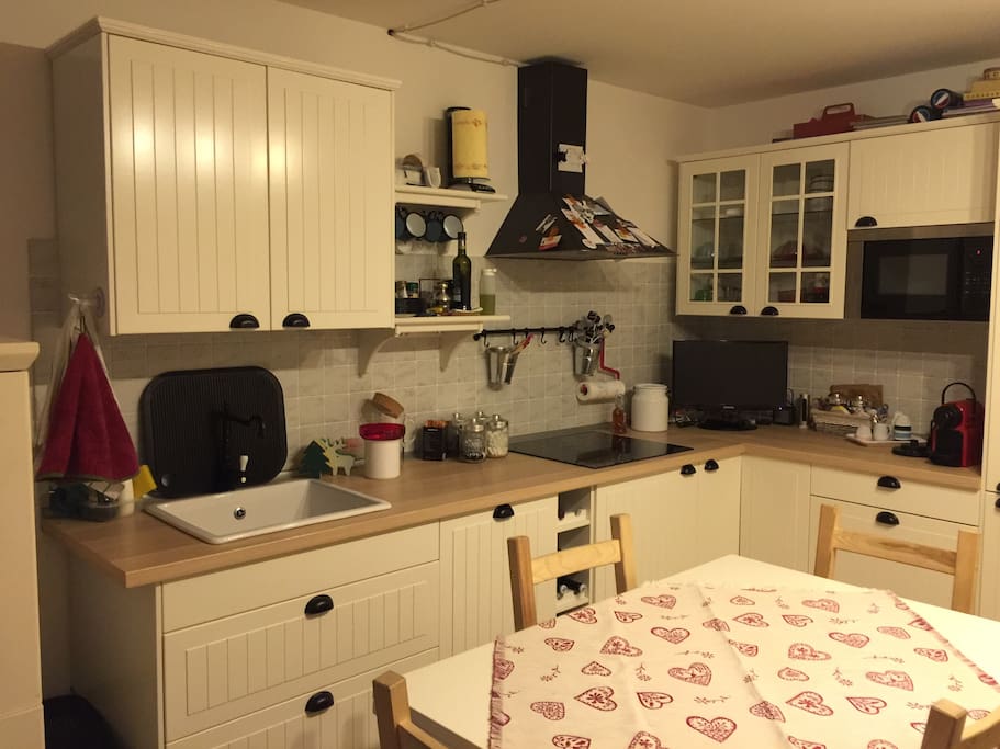 Cucina con lavastoviglie e lavatrice nascosta. Forno a microonde piano ad induzione.