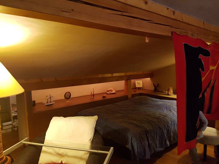 נוף לחדר השינה הראשי עם אזור שולחן קטן; גם מתחת לגגות: קן קטן ונעים