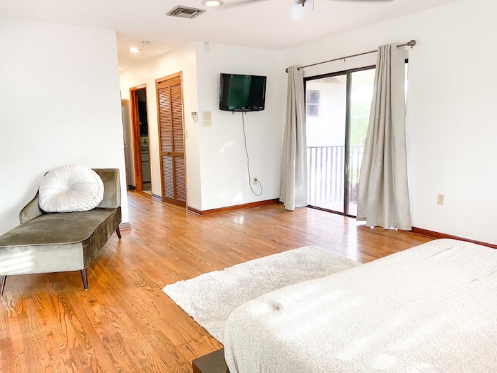 Suite superior con TV, sillón, cama KIng y balcón al patio trasero.