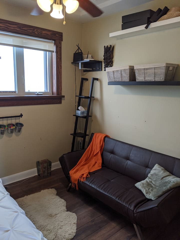 חדר שינה לאורחים עם ספה שיכולה לשמש כמיטה זוגית נוספת.