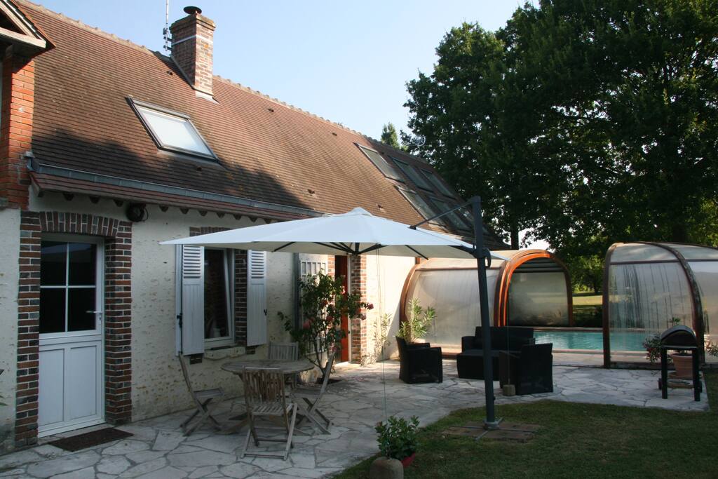 Terrasse avec salon , table et barbecue.