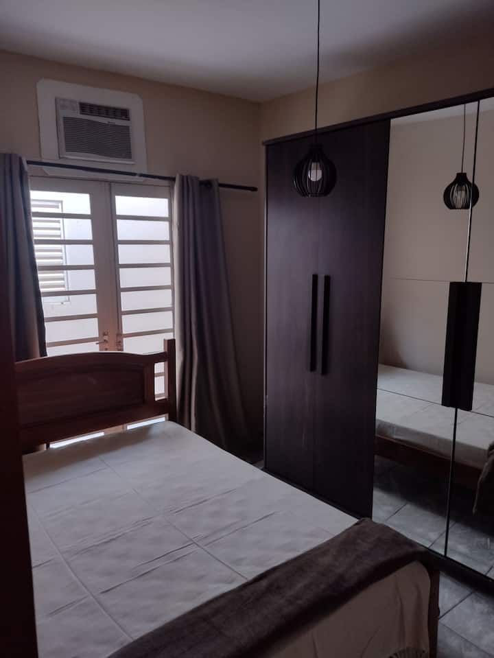 Dormitorio doble con un armario espacioso, aire acondicionado y una relajante vista al solárium, donde puedes usar la hamaca y contemplar las estrellas por la noche.