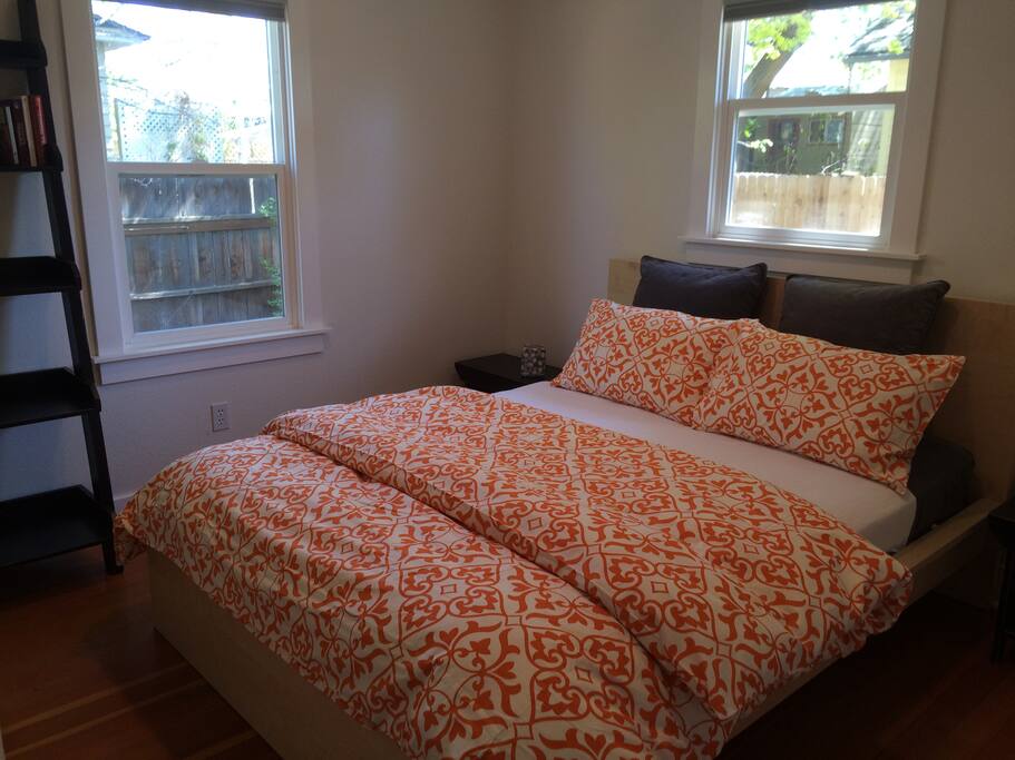 Bedroom 2 is cozy, fully enclosed with a queen sized bed and lovely natural lighting.