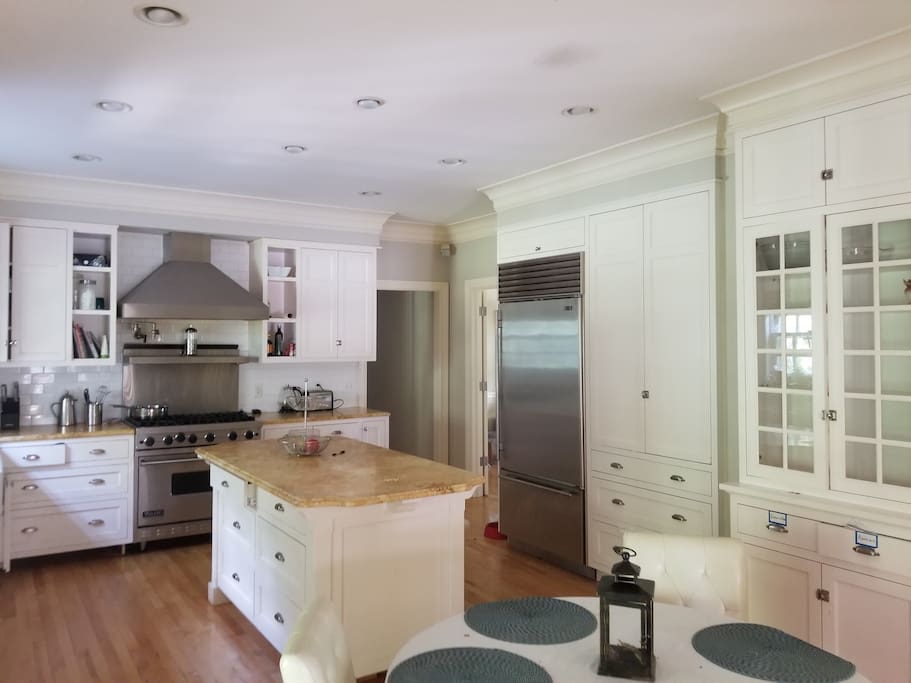 Large eat in kitchen with subzero fridge, viking stove and limestone countertops