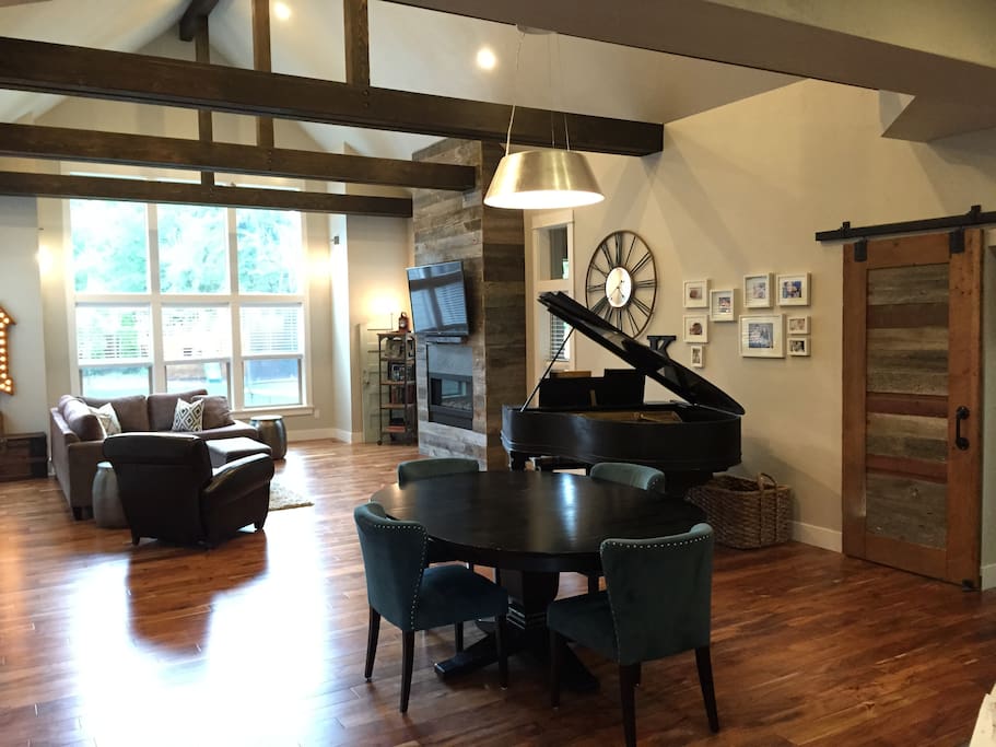 Extremely large family room with cathedral ceilings, grand piano, 60" flatscreen, dining area and open floorplan to adjacent kitchen
