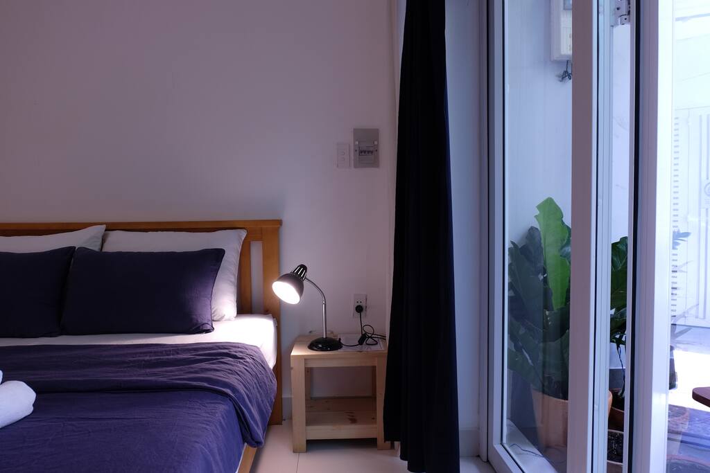 Cosy bedroom with comfortable bed and greenery alley view