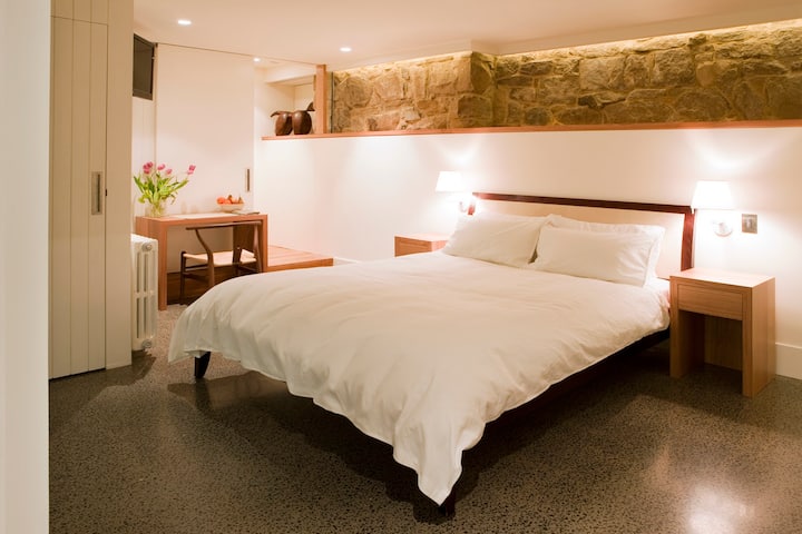 Downstairs double bedroom with sandstone wall and concrete heated floor