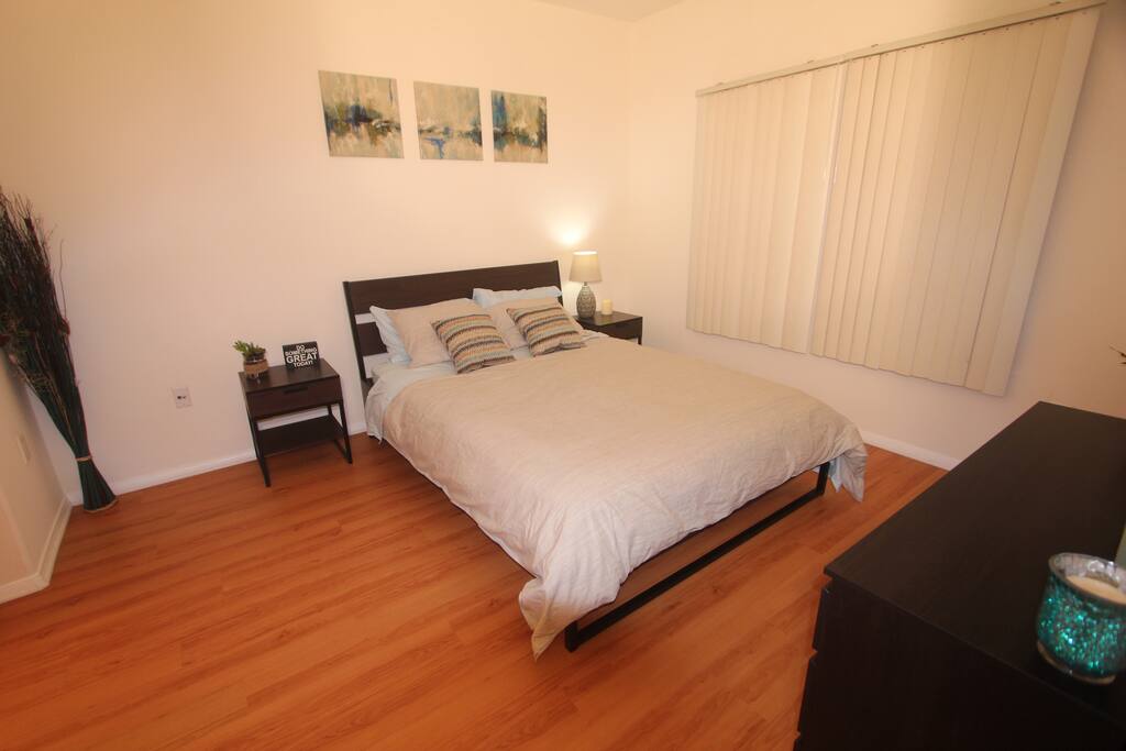 Queen size bed in a very cozy bedroom.