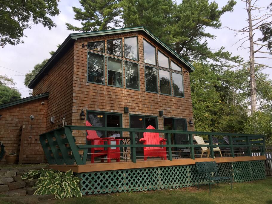 The Ocean side of the house with a large deck, fire pit, access to the dock, and an outdoor shower.