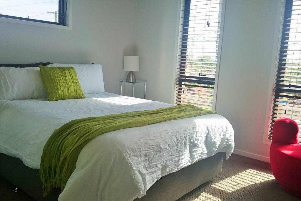 Large aircon room with comfortable Queen bed, wardrobe and chair