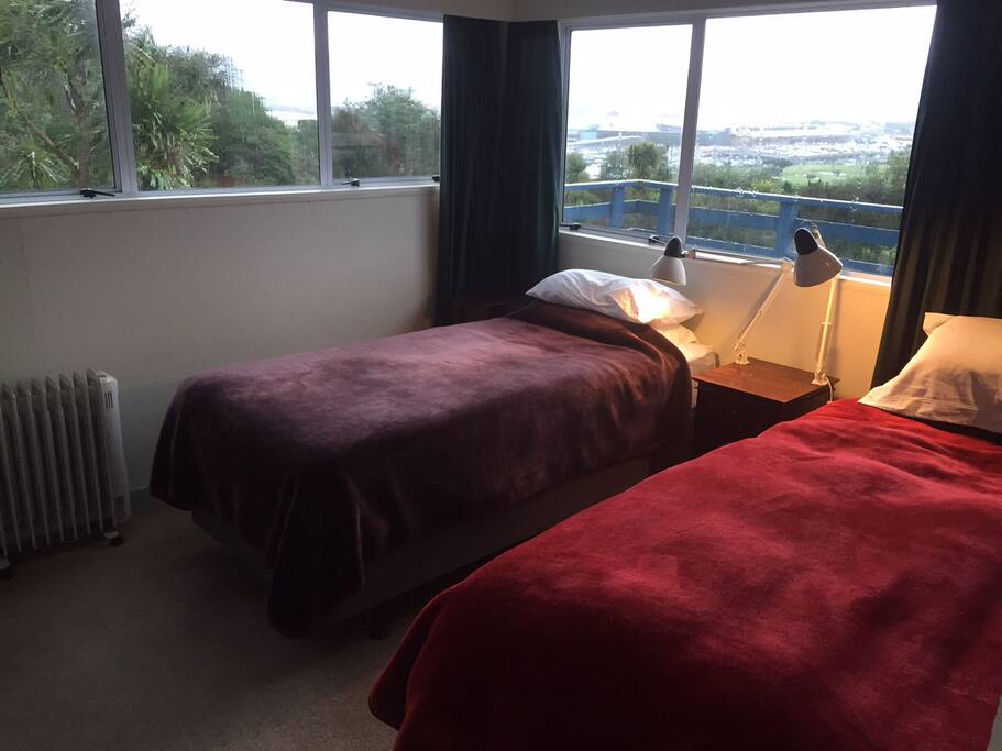 Upstairs bedroom with two king single beds in sunny warm room