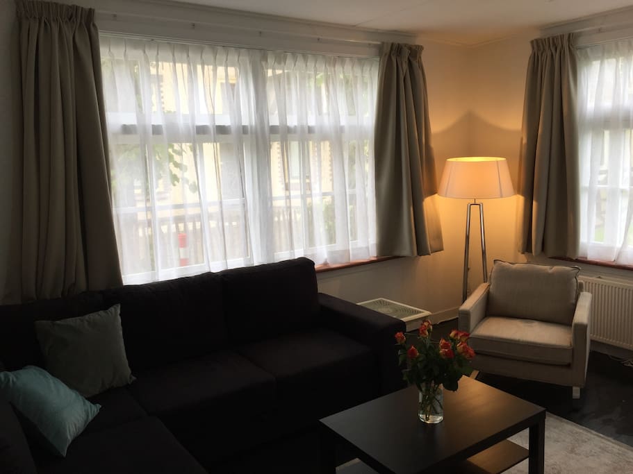 The light livingroom has an armchair and a corner sofa which can be turned into a queensize bed. The livingroom includes a large screen tv.