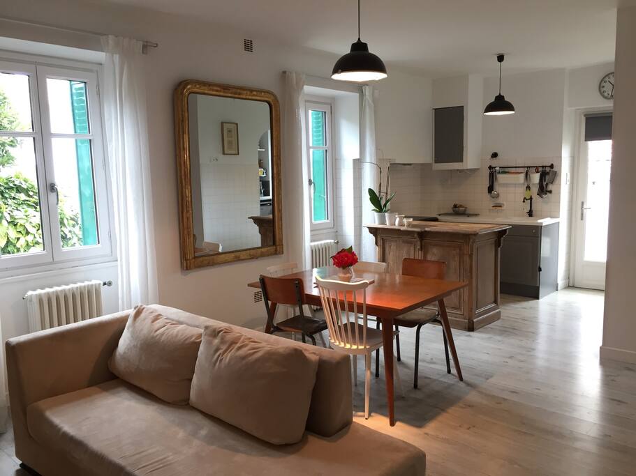 Salon et cuisine ouverte avec porte vers le jardin et la terrasse