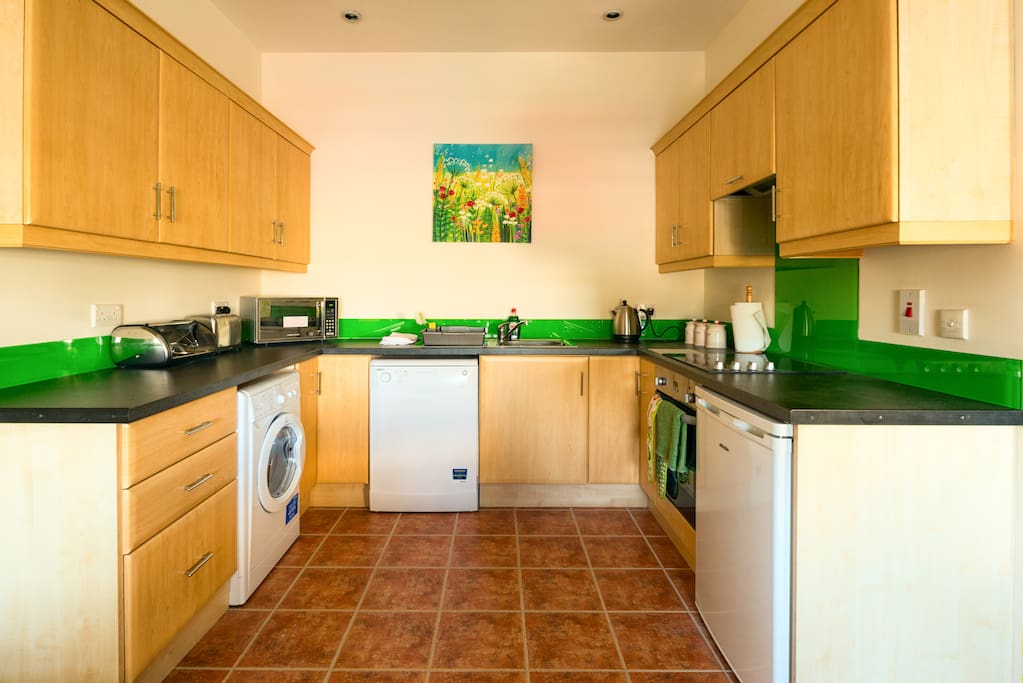 Fully fitted well equipped kitchen has crockery and utensils with oven, hob, microwave, dishwasher, washer/drier.