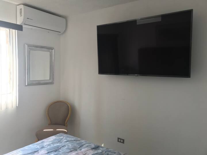 55-inches TV on bedroom # 2 . Air conditioning shown on the side wall  