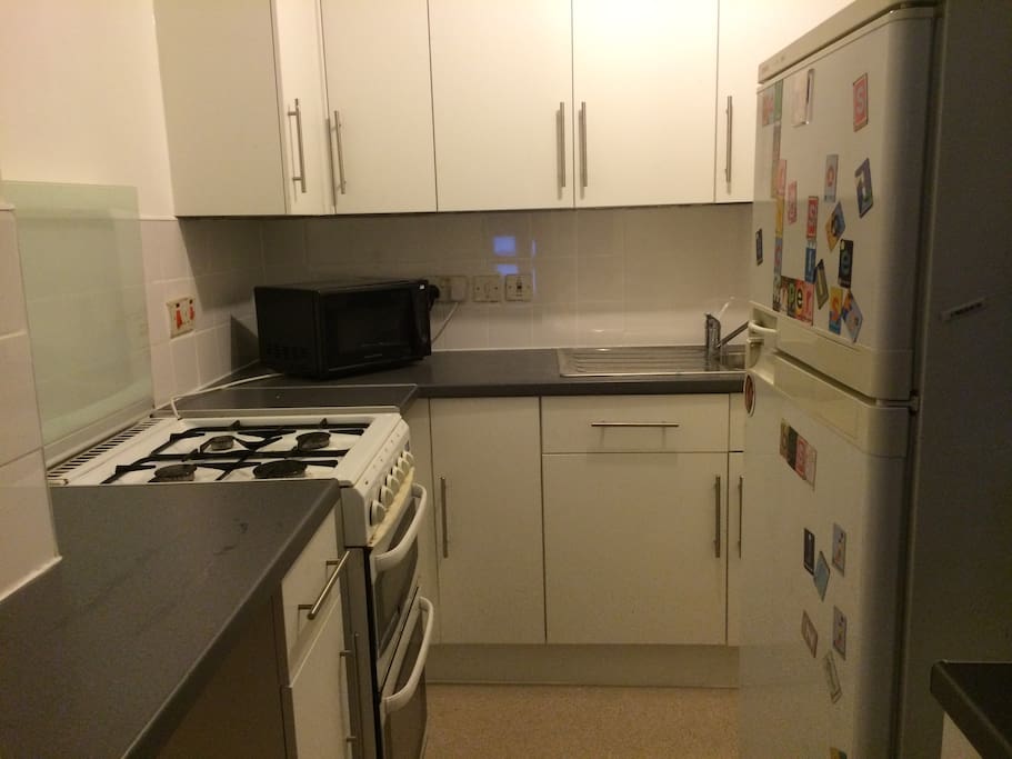 open plan kitchen, with sink, fridge and gas cooker
