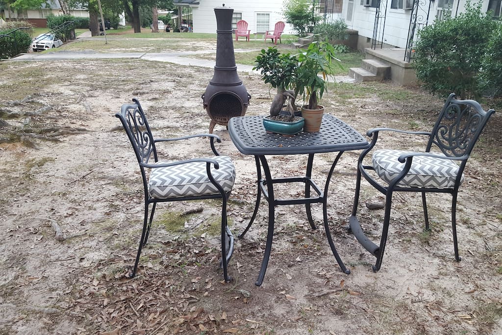 A little outdoor seating area by the chiminea/fireplace. More folding chairs are available for a larger group, as well as a charcoal grill.